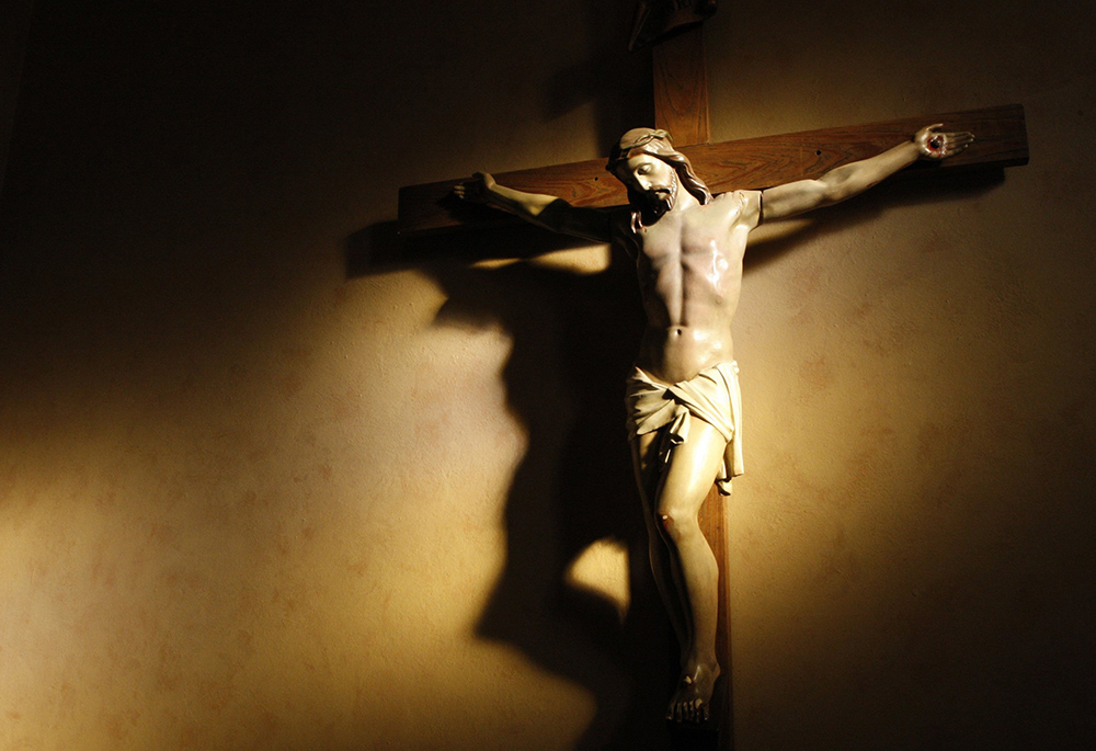 Evening light shines on a crucifix in the vestibule of St. Paul's Basilica in Toronto in this 2008 file photo. In his new book, James Keenan begins his narrative with the New Testament. (CNS/Nancy Wiechec)
