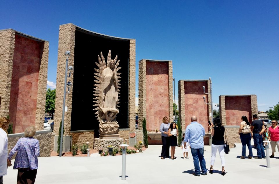 People pose for photos in front of St. Mark's 30-foot statue of Our Lady of Guadalupe, which Fr. Arturo Bañuelas purchased from Guadalajara, Mexico. (NCR photo/Soli Salgado)