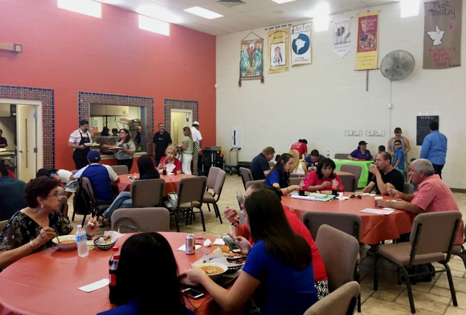 Lunch in the community center, following the 12:30 Spanish Mass at St. Mark Church in El Paso, Texas. Ministries alternate serving lunch as a fundraiser, and banners representing various ministries hang on the walls. (NCR photo/Soli Salgado)