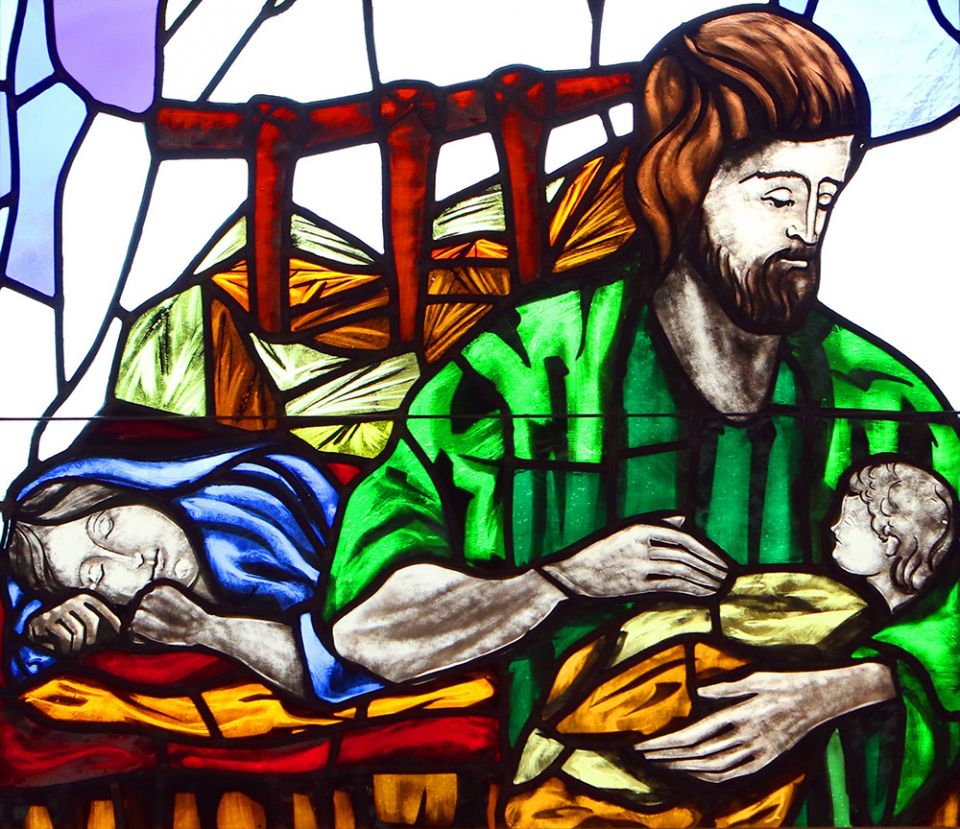 A depiction of St. Joseph cradling the infant Jesus while Mary sleeps is seen in a stained-glass window at St. Patrick Church in Smithtown, New York. (CNS/Gregory A. Shemitz)