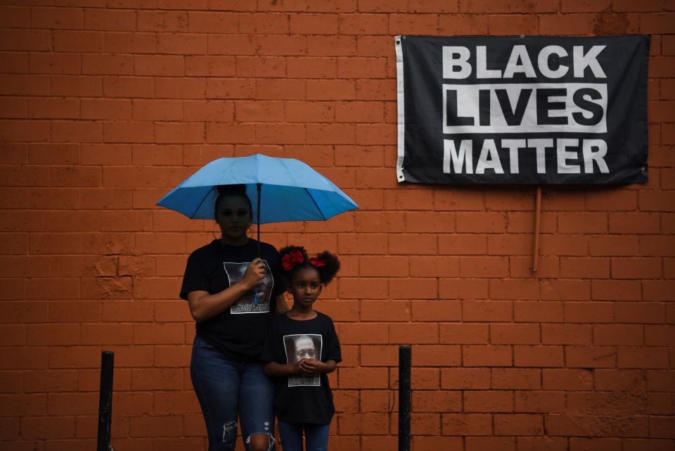 Brittany Elmore of Houston poses for a photo with her daughter Brooklyn near a "Black Lives Matter" sign May 23. (CNS)