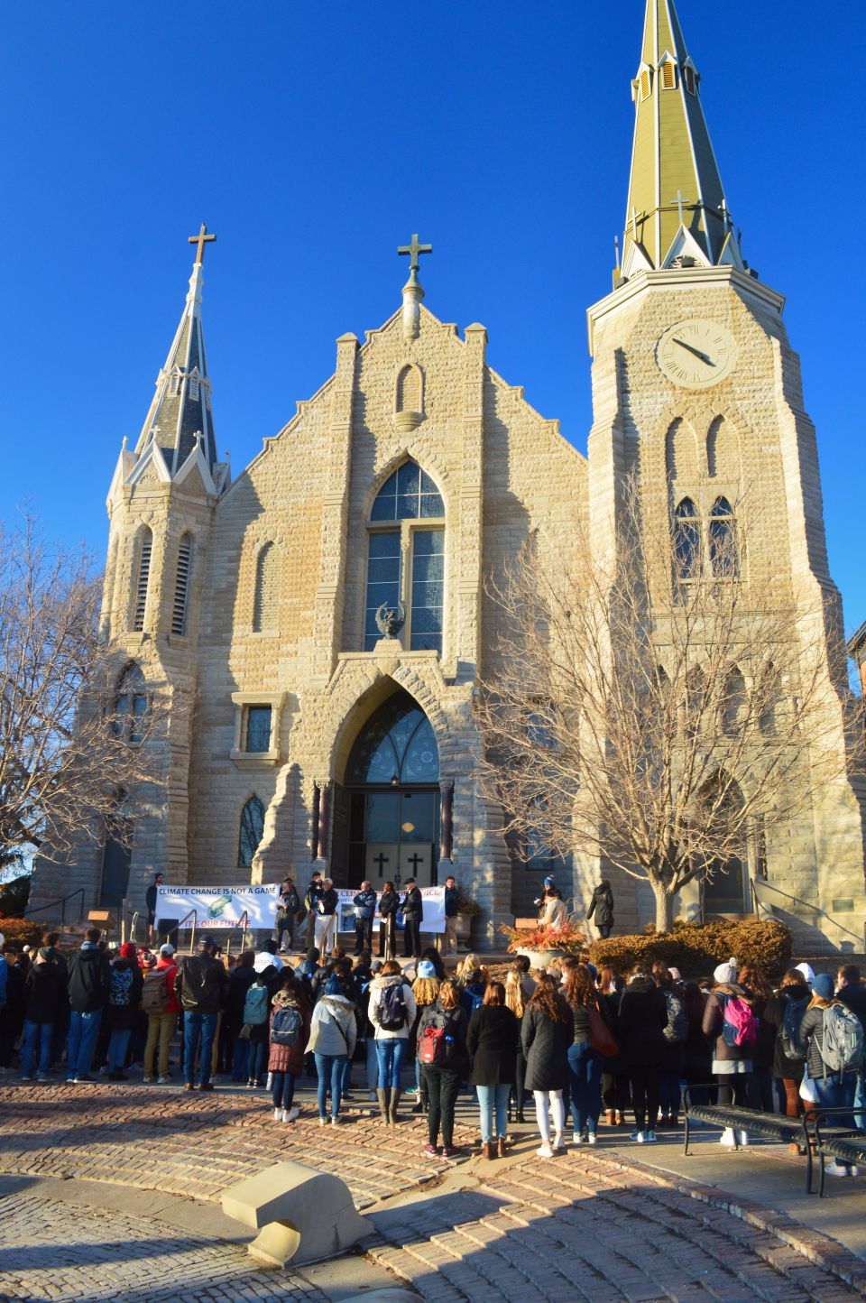 Students and others gather on the steps of St. John Church on the Creighton University campus in Omaha, Neb., Feb. 20, 2020, for a prayerful rally to call on school leaders to divest from fossil fuels. (CNS photo/courtesy Emily Burke)