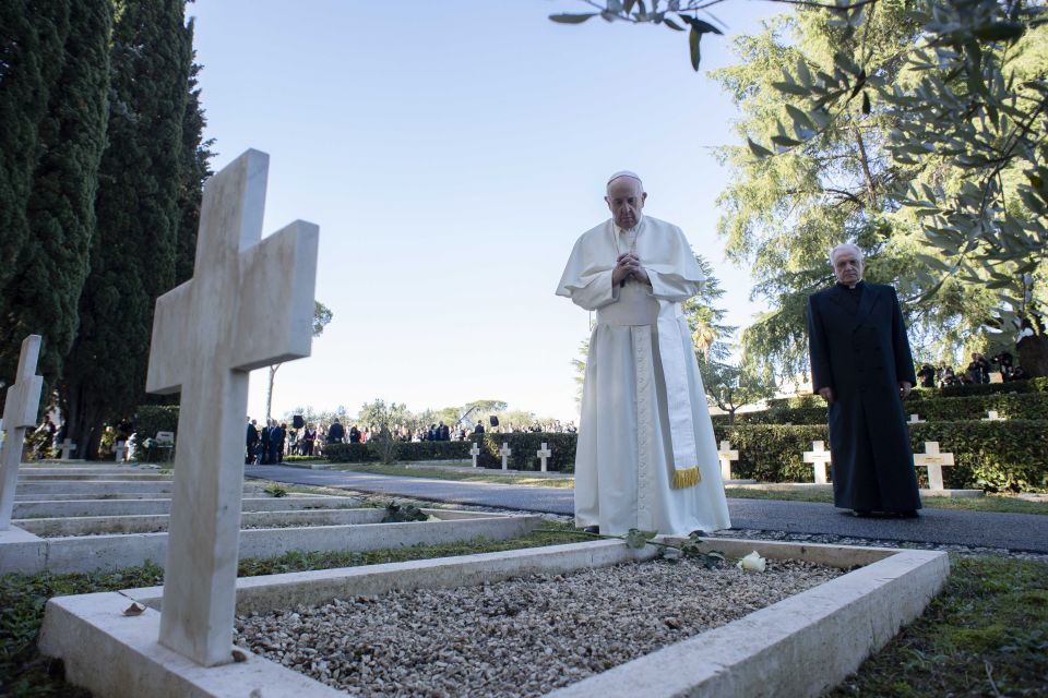 Pope Francis prays at a grave at the French Military Cemetery before celebrating Mass for the feast of All Souls at the cemetery in Rome Nov. 2, 2021. (CNS photo/Vatican Media)