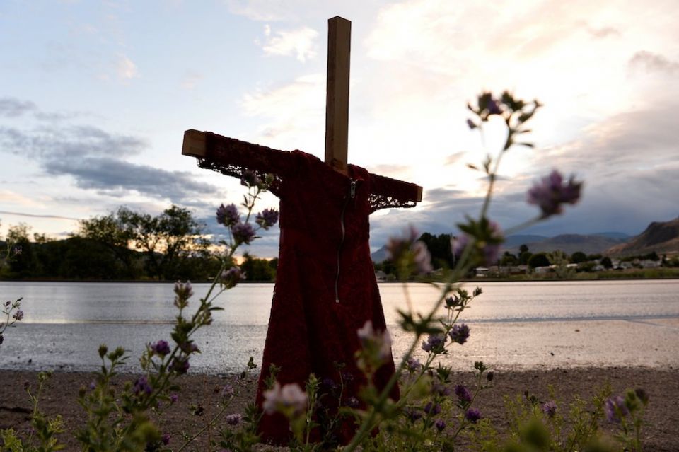 A child's red dress hangs on a stake near the grounds of the former Kamloops Indian Residential School in Kamloops, British Columbia. For years, Indigenous people in Canada have wanted an apology from the pope — on Canadian soil — for the church's role in