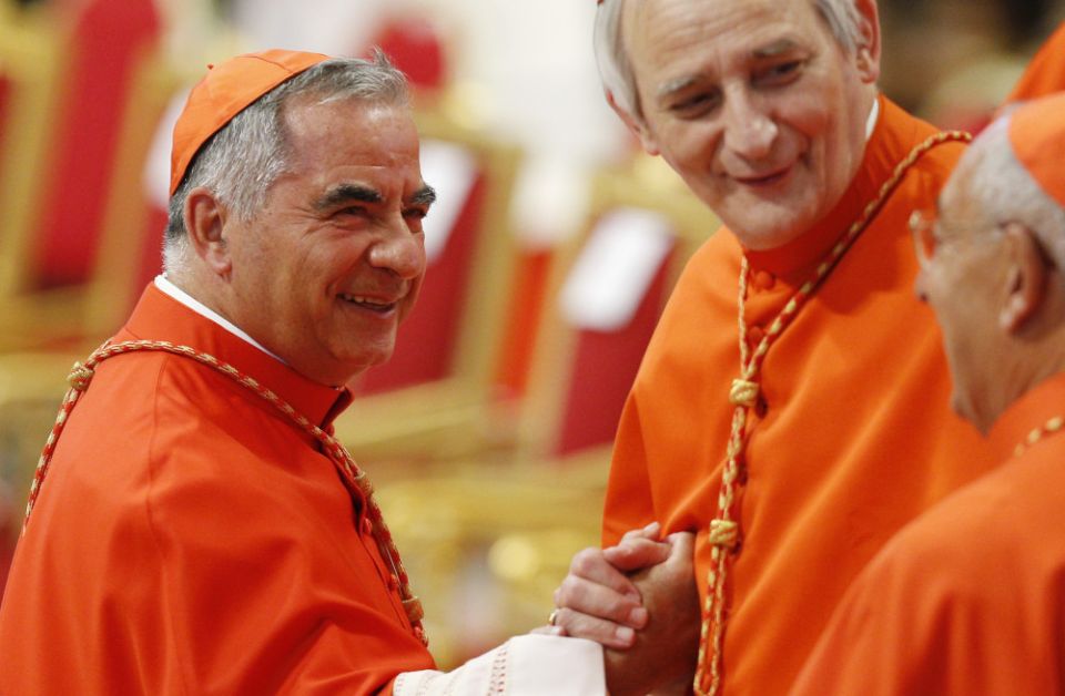 Cardinal Angelo Becciu, left, greets Cardinal Matteo Zuppi of Bologna as he arrives for a consistory led by Pope Francis for the creation of 20 new cardinals in St. Peter's Basilica at the Vatican Aug. 27, 2022. (CNS photo/Paul Haring)
