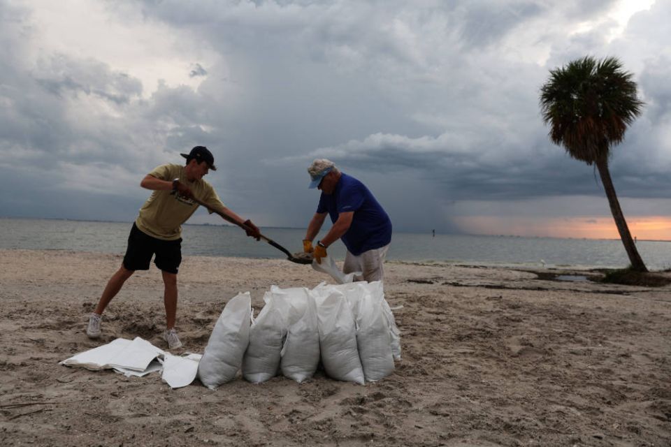 Rich Reynolds and his son, John, fill sandbags in Tampa, Fla., Sept. 26, 2022, as Hurricane Ian spun toward the state. (CNS photo/Shannon Stapleton, Reuters)