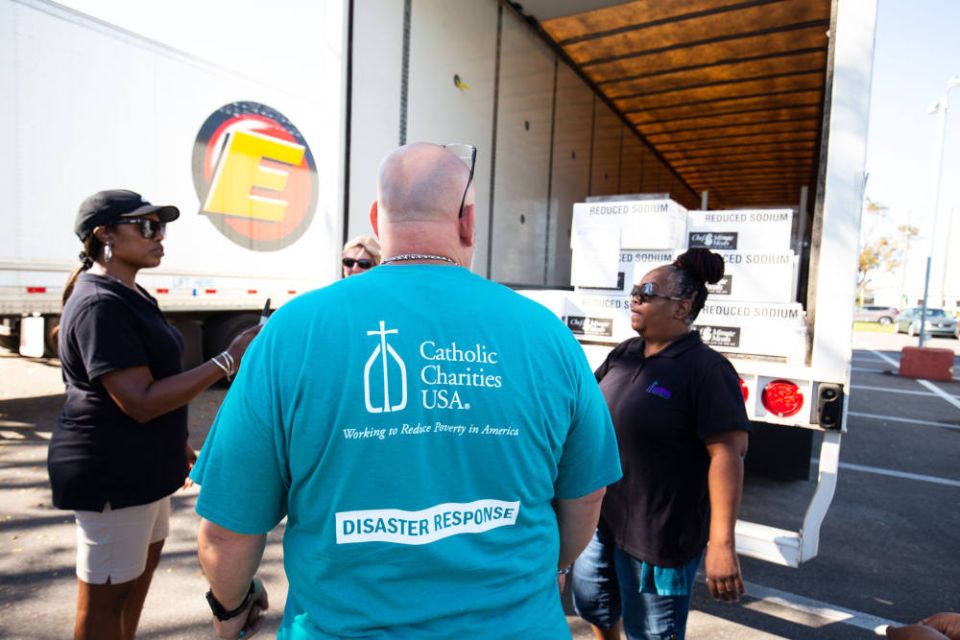 Staff and volunteers with Catholic Charities of the Diocese of Venice, Fla., unload emergency supplies for distribution at the Elizabeth Kay Galeana Catholic Charities Center in Fort Myers Oct. 5, 2022, following Hurricane Ian. (CNS photo/Tom Tracy)