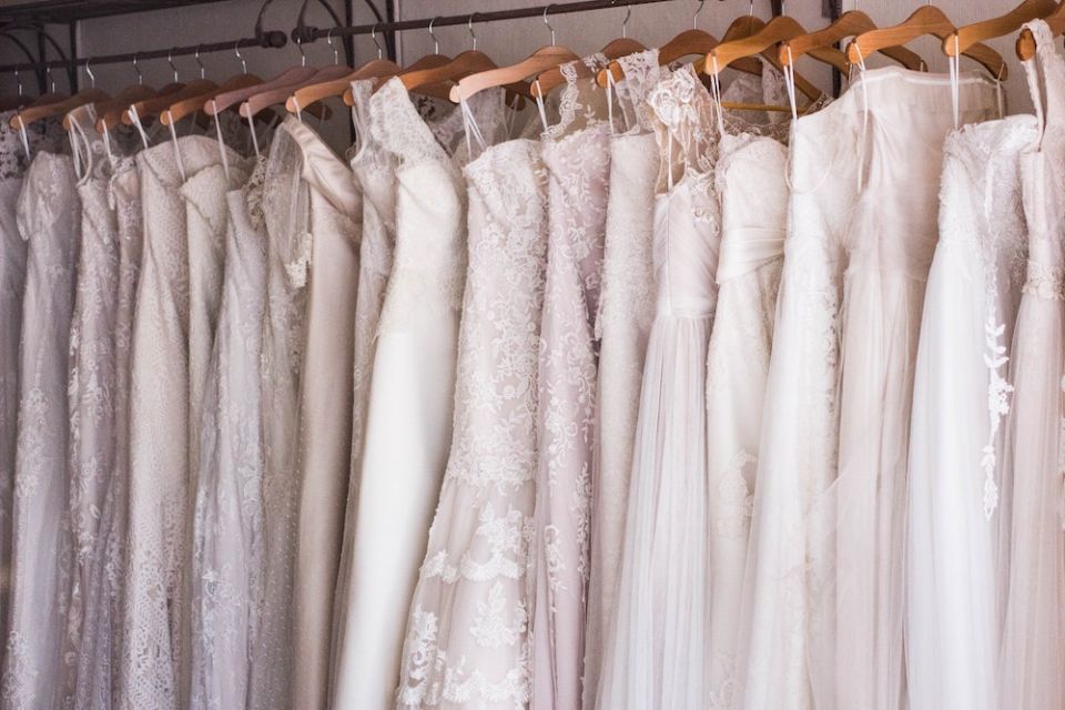 Wedding dresses hanging on a rack (Unsplash/Charisse Kenion)