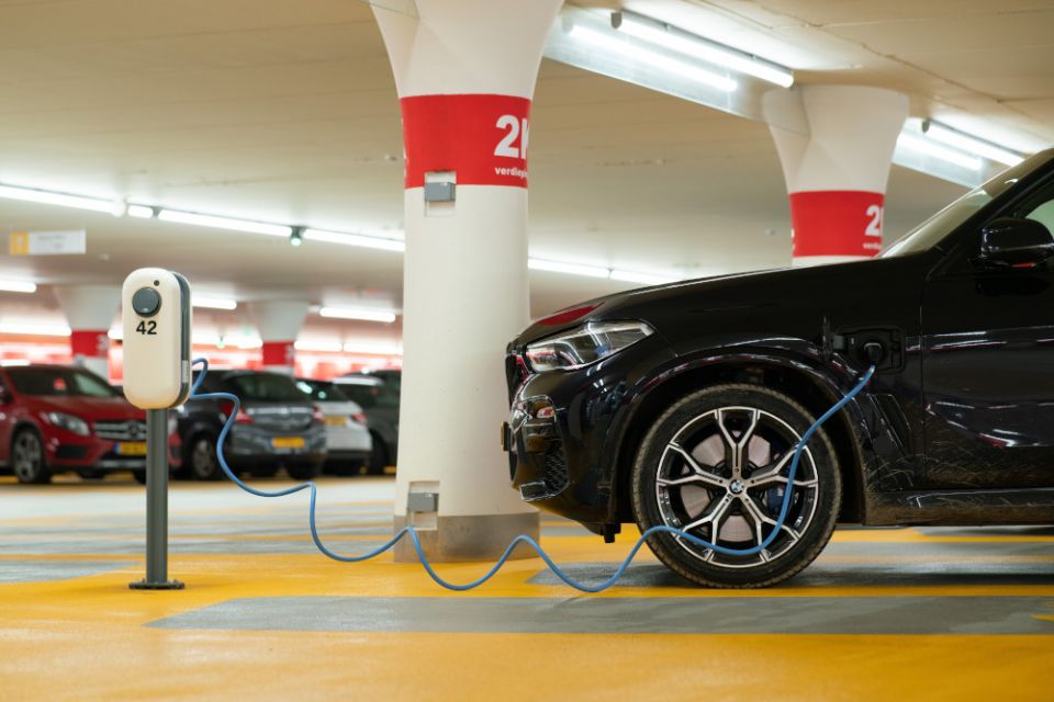 Electric vehicle charging in a garage. (Unsplash/Michael Fousert)