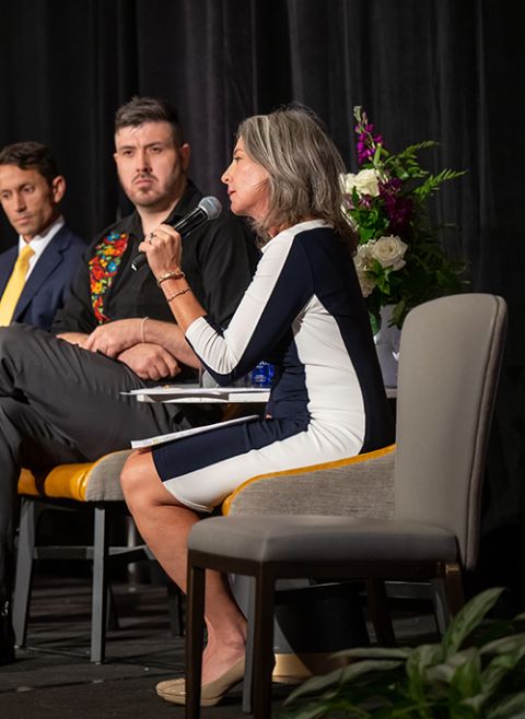 An empty chair was added to the stage during the Catholic Partnership Summit in Washington. Also pictured: Krisanne Vaillancourt Murphy, right; Vicente Del Real, center; and John Cannon, left. (Maximilian Franz Photography)