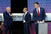Arizona Republican Senate candidate Blake Masters, right, looks on as Democratic Sen. Mark Kelly, left, talks with Libertarian candidate Marc Victor ahead of a televised debate in Phoenix Oct. 6. 