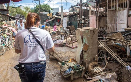 A Catholic Relief Services official walks through the aftermath of Typhoon Vamco, known locally as Ulysses, which made landfall on the Philippines on Nov. 11, 2020. Its destructive winds and intense rains triggered extensive flooding in several areas.